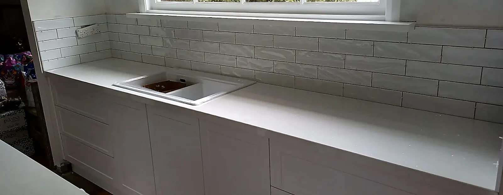 Renovated white kitchen with new cabinets, benchtop and subway-tile splashback